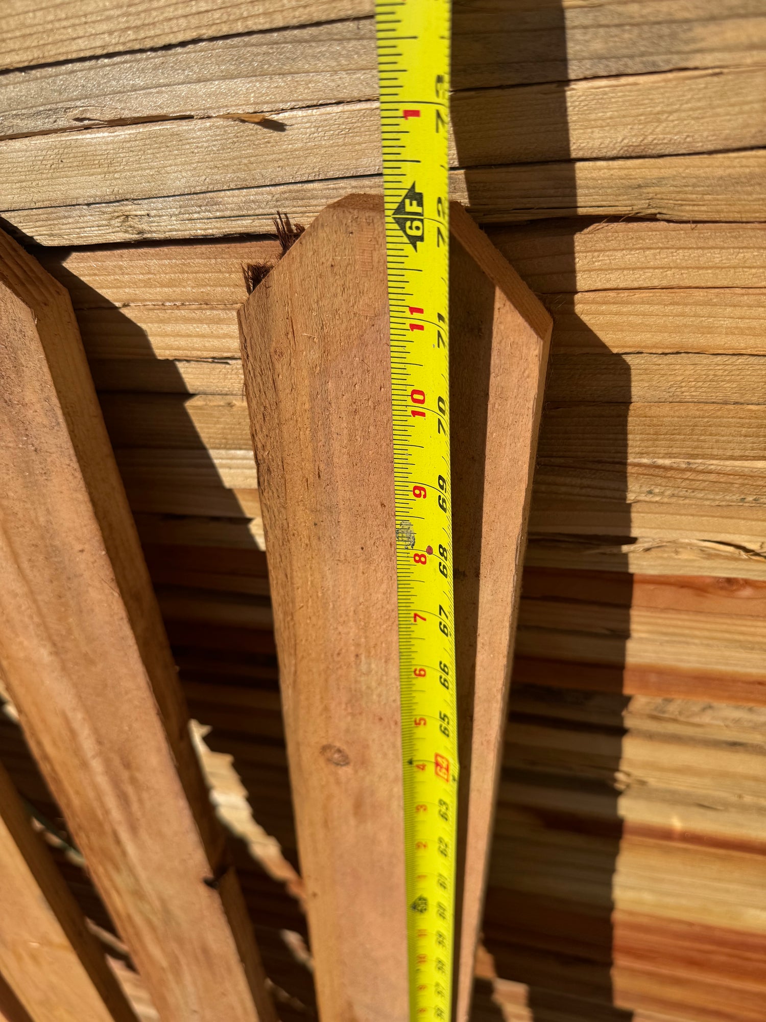 Height measurement of dog-ear redwood fence picket showing the picket at 6' tall